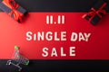 11.11 Single day sale. Black gift with red ribbon on black and red color background and small cart on black color background with Royalty Free Stock Photo