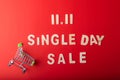 11.11Single day sale. Small cart with 11.11 single`s day sale text was made from wood on red color background. Top view Royalty Free Stock Photo