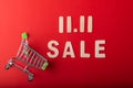 11.11Single day sale. Small cart with  11.11 sale text was made from wood on red color background. Top view Royalty Free Stock Photo