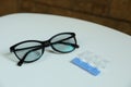 Single dose eye drops and glasses on white table Royalty Free Stock Photo