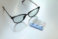 Single dose eye drops and glasses on white table Royalty Free Stock Photo