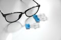 Single dose eye drops and glasses on white table Royalty Free Stock Photo