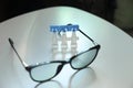 Single dose eye drops and glasses on white table Royalty Free Stock Photo