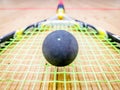 Single dot squash ball on racquet stings