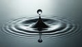 Single drop falls into still water creating circular ripples. Liquid splash forms abstract pattern of concentric waves. A moment Royalty Free Stock Photo