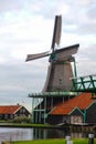 Single dutch windmill with a traditional wooden house in a Netherland`s landscape. Royalty Free Stock Photo