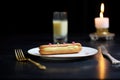 a single eclair with a candle on it, like a birthday treat Royalty Free Stock Photo