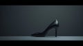 A single elegant colored high-heeled shoe, perfectly positioned against a flat background, symbolizes timeless fashion.