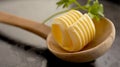 Single elegant ridged butter curl in wooden spoon