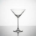 An empty clear glass martini cocktail glass with a long stem on a reflective surface Royalty Free Stock Photo
