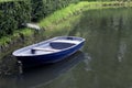 Single empty old blue boat moored in a green thickets Royalty Free Stock Photo