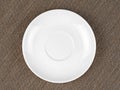 Single Empty White Plate on Coarse Fabric or Bagging