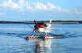 Single engine seaplane on blue waters and blue skies in the background. .