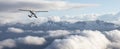 Single Engine Seaplane Flying over the Rocky Mountain Landscape. Royalty Free Stock Photo