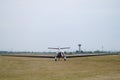 Single engine smaill aircraft landing on a grass airfield