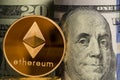 Single Ethereum coin in front of bank rolls of US currency