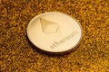 Single ethereum coin on golden glittering background