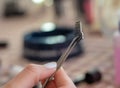 A single eyelash set with glue isolated in focus. Being held in hand with tweezers before being put on as a make up routine