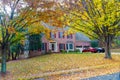 Single-family brick country house with yellow trees in the frontyard. Autumn landscape Royalty Free Stock Photo