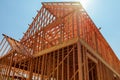 A single family home under construction. The house has been framed and covered in plywood.