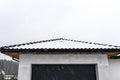 Single-family house roof covered with snow against a cloudy sky. Visible roof trusses, ventilation tile, garage door Royalty Free Stock Photo