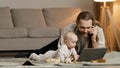 Single father adult stressed business man multitasking dad lying on floor at home with little daughter talking on phone Royalty Free Stock Photo