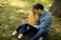 Single father sitting on grass by the tree with little daughter Royalty Free Stock Photo