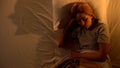 Single female sleeping in bed, suffering nightmares, monster shaped shadow, fear