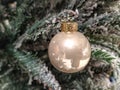 Single festive ornament on a christmas tree as a decoration in a warm home an frosty pine tree needles