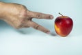 A single finger points playfully at a red and yellow apple, as if in a game of rock-paper-scissors. Royalty Free Stock Photo