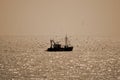 A single fishing boat contre jour