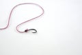 A single fishing hook hooked with red rope on white background