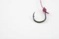 single fishing hook hooked with red rope on a white background