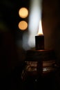 Single flame on small oil lamp with dark and blurred background