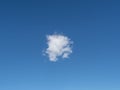 Single fluffy cloud in bright blue sky, serene atmosphere. Royalty Free Stock Photo