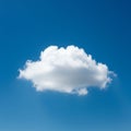 A single, fluffy cumulus cloud is set against a bright blue sky. The cloud appears white Royalty Free Stock Photo