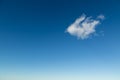 Single fluffy white cloud against deep blue sky Royalty Free Stock Photo