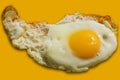 Single fried egg isolated on yellow background Royalty Free Stock Photo