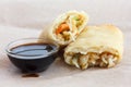 Single fried vegetable spring roll on wax paper.