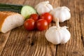 Single garlic head in front of other vegetable and baguette Royalty Free Stock Photo