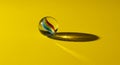 A single glass marble rests on a bright yellow surface. Inside the clear marble, vibrant Royalty Free Stock Photo