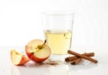 A single glass of white wine beside fresh apple slices and a cinnamon stick Royalty Free Stock Photo