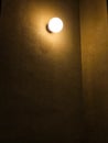 Single Glowing Light Bulb on Dark Textured Wall Royalty Free Stock Photo