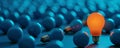 Single glowing orange bulb among many blue bulbs, concept of individuality and uniqueness Royalty Free Stock Photo