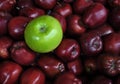 Single Green Apple with Bunches of Red Apples Royalty Free Stock Photo