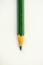 Single green pencil lies on a light background, close-up.
