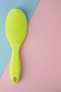 Single green plastic comb for hair on pink Royalty Free Stock Photo