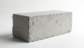 Single grey concrete block sits on white surface. Rough texture shows small holes, imperfections. Object appears solid, Royalty Free Stock Photo