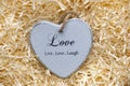 Single grey wooden heart in a love nest