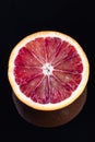 Single half of a blood orange isolated on black Royalty Free Stock Photo